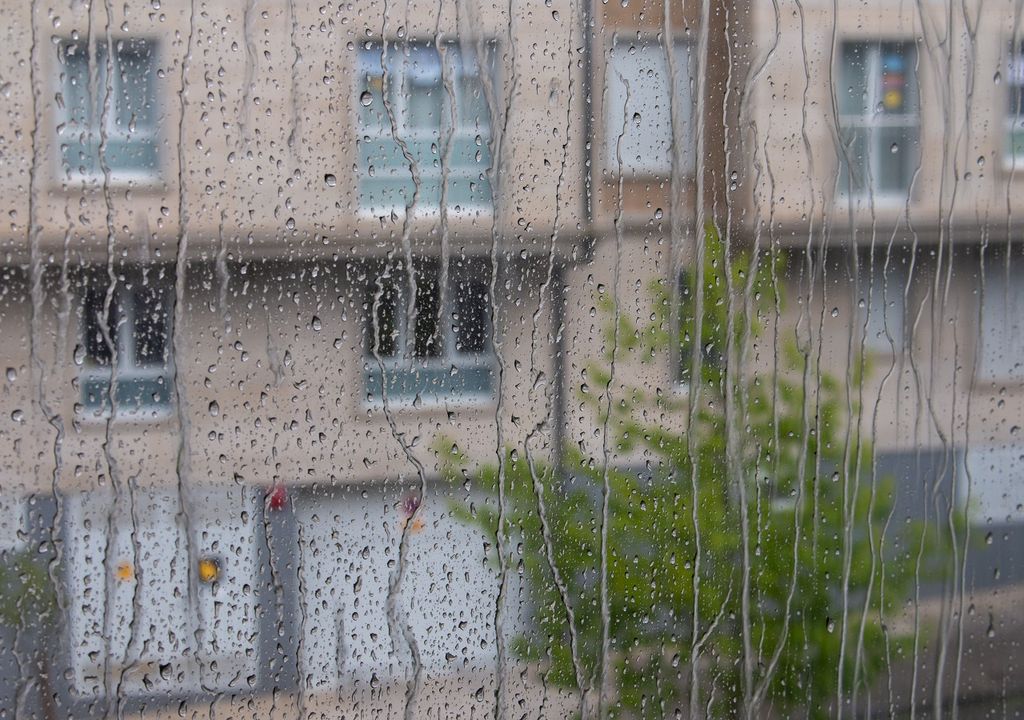 edificios vistos a través de ventana mojada con lluvia