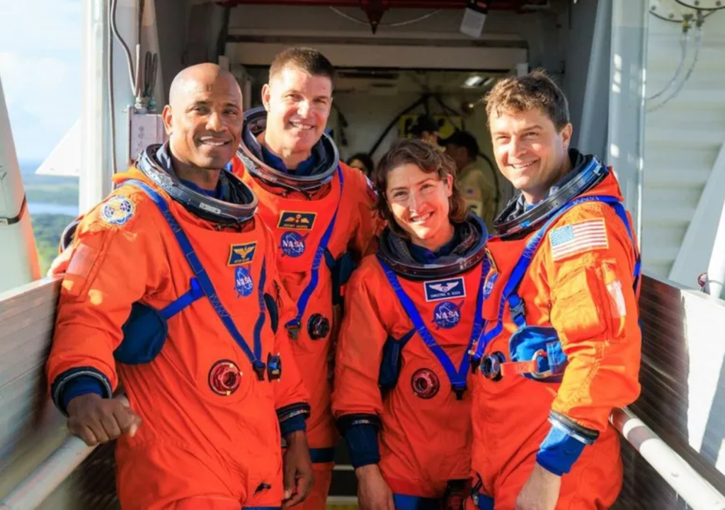 La tripulación sonríe en la plataforma de lanzamiento, vestida con trajes de vuelo naranja, lista para una nueva misión que une ciencia, coraje y colaboración. Crédito: NASA