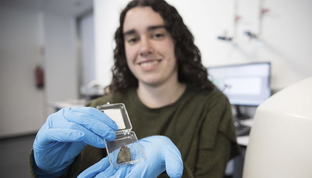 Leire Coloma, investigadora predoctoral en la EHU, enseñando una muestra de meteorito. Crédito: Egoi Markaida - EHU