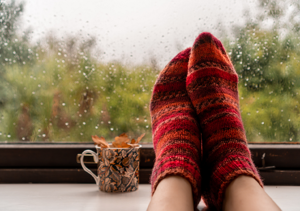 persona con los pies apoyados en la ventana