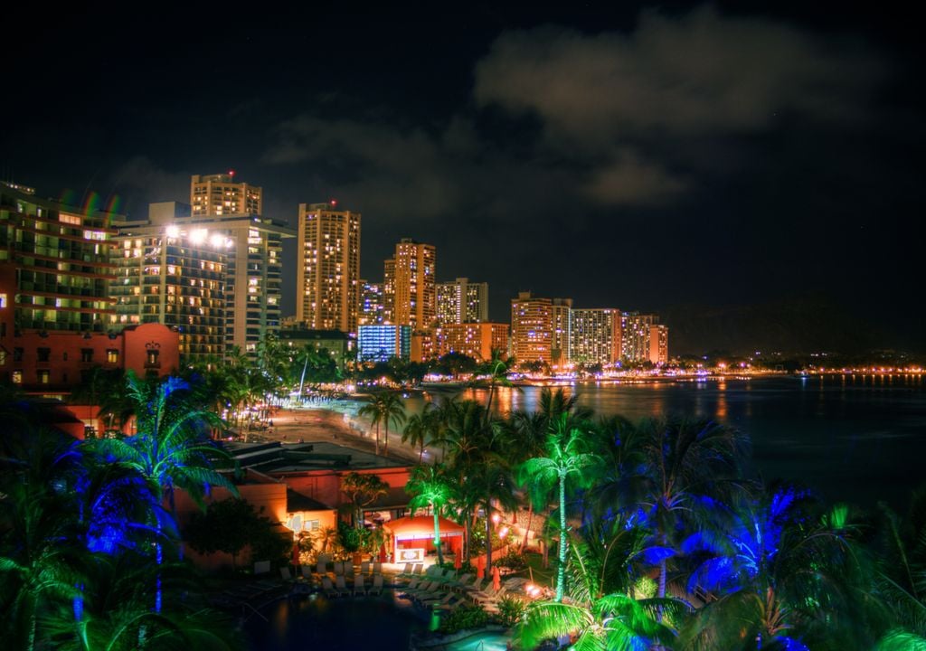 Praia em área urbana com luzes de cores diversas.