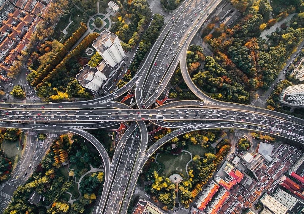 carretera urbana y sectores de una ciudad con arborización, desde una perspectiva aérea