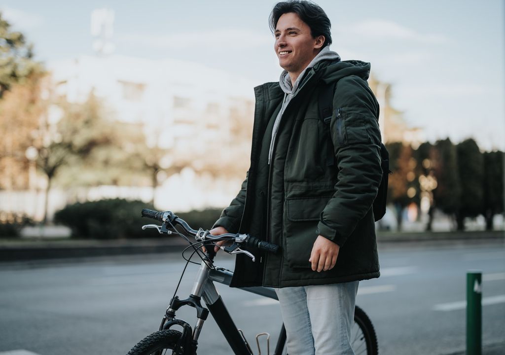 persona con parka al lado de una bicicleta persona con parka al lado de una bicicleta