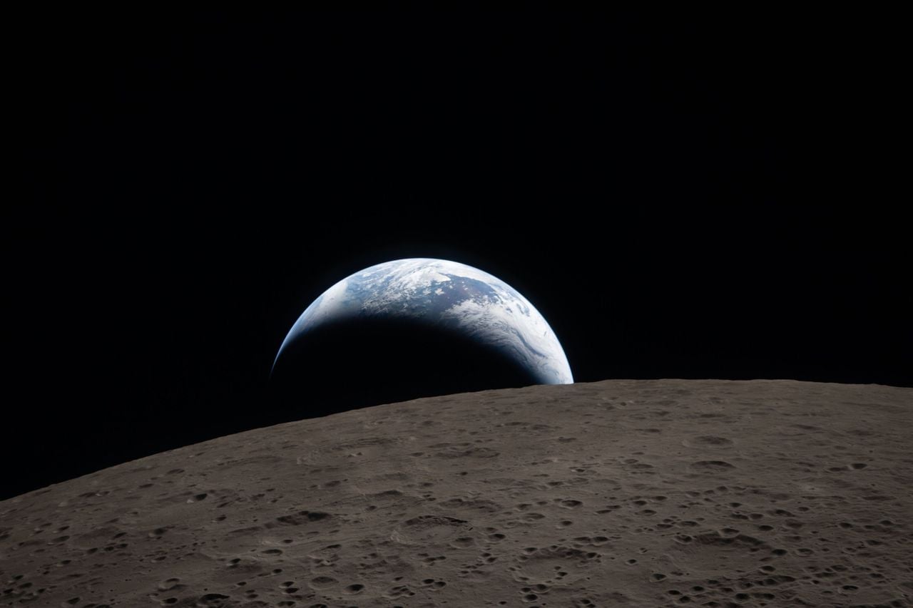 Imagen de la Luna desde Artemis II del 6 de abril 2026 con la Tierra al fondo con sus nubes blancas y mares azules. Fuente NASA
