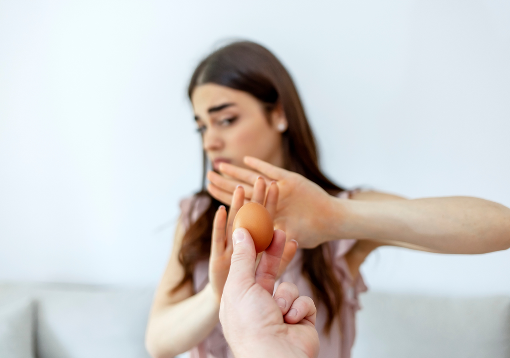 Mujer rechazando un huevo Mujer rechazando un huevo