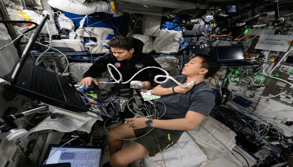 A astronauta da NASA Anne McClain auxilia o astronauta Jonny Kim durante uma ecografia a bordo da Estação Espacial Internacional. Fonte: NASA