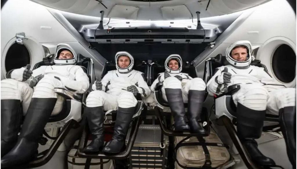 Os membros da missão SpaceX Crew-13, vestidos com os seus fatos pressurizados, estão sentados no interior de uma réplica da nave Dragon durante uma sessão de treino antes do voo, na sede da empresa, em Hawthorne, na Califórnia. Fonte:PHYSORGN