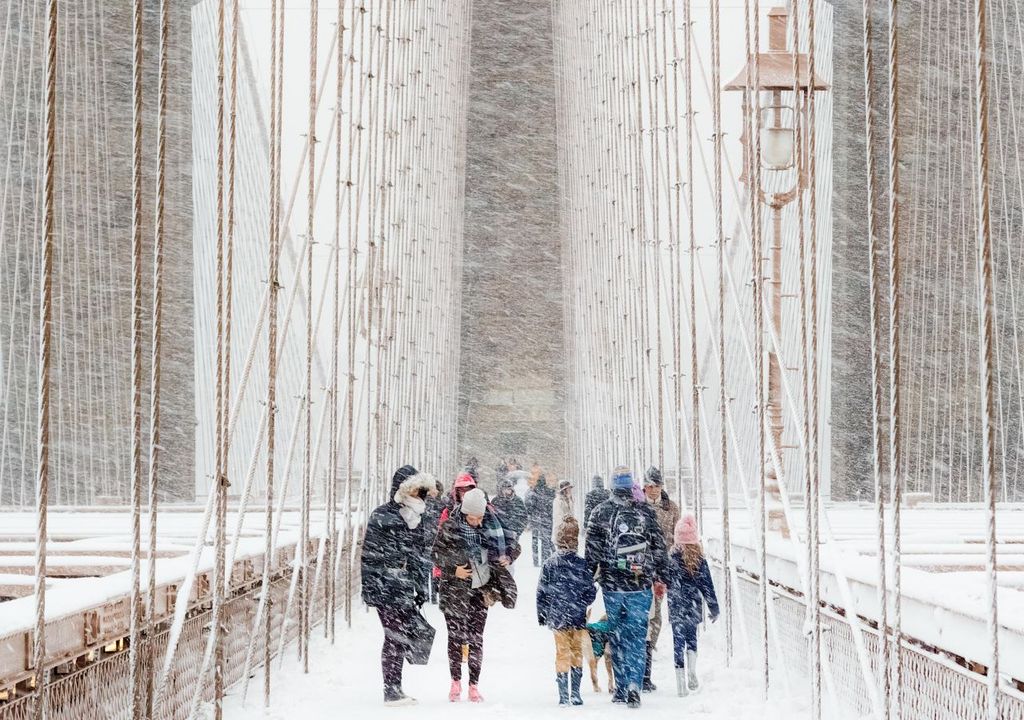 People walking across Brooklyn Bridge in a blizzard © Rudolf Sulgan