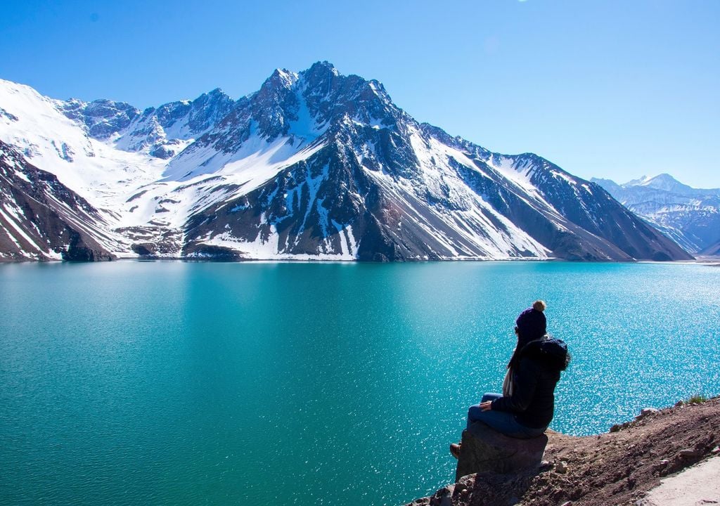 Mujer sentada frente a embalse El Yeso, Región Metropolitana