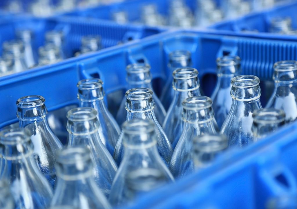 botellas de vidrio transparentes en un engradado azul