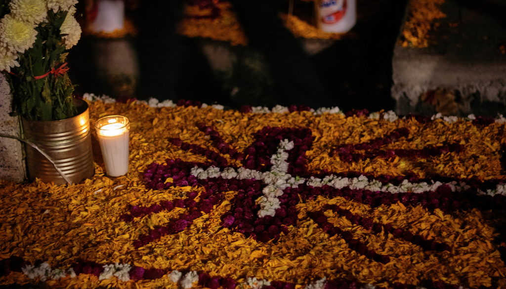 Los pétalos de cempasúchil se combinan con flores blancas y moradas para formar diseños tradicionales que adornan las ofrendas.