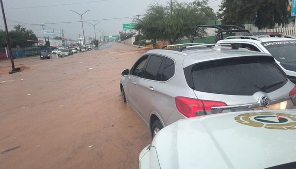 Brigadistas, buscan a dos personas arrastradas por un arroyo en la frontera de Nogales tras una fuerte tormenta.