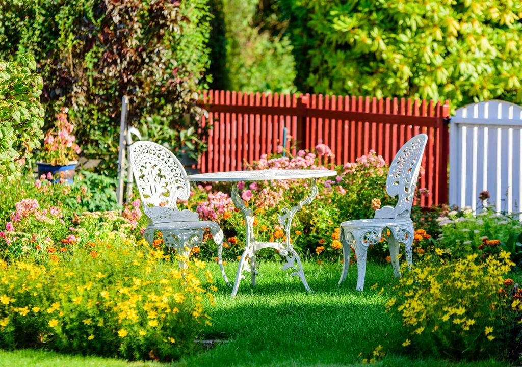 Tavolino con sedie in un giardino fiorito