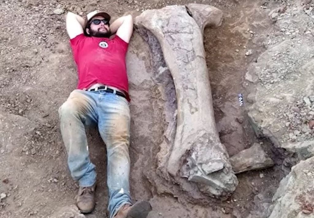 Paleontólogo da Universidade Federal de Santa Maria, Leonardo Kerber, deitado ao lado do fóssil descoberto. Crédito: Reuters