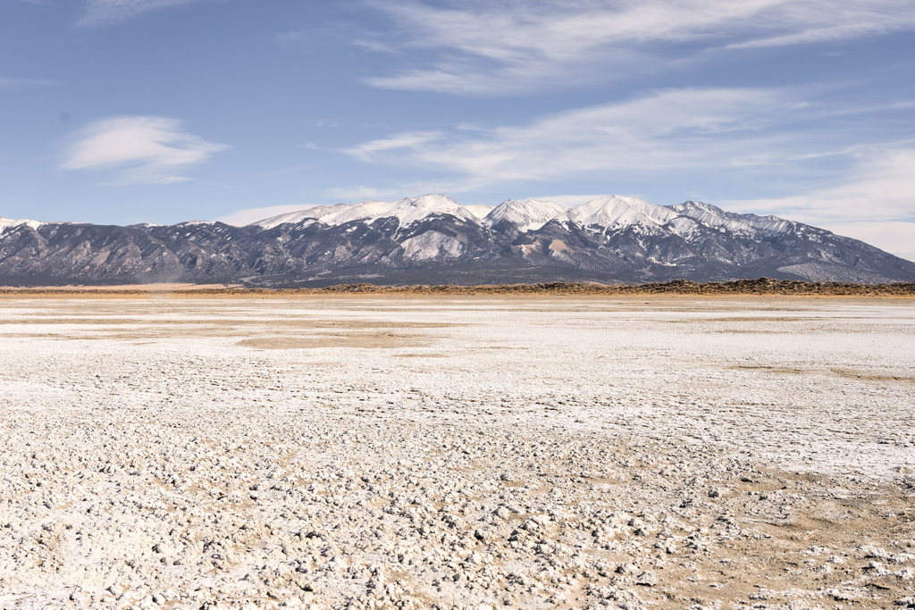 dry lake with snow covered mountains