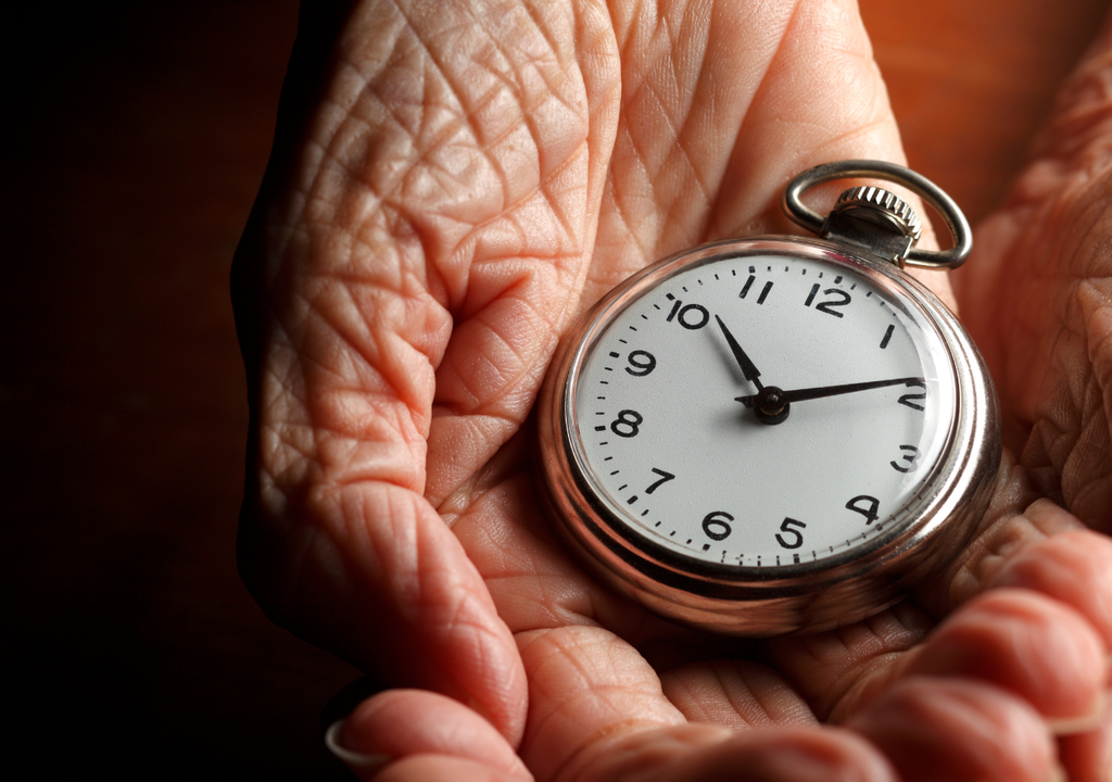 reloj y mano arrugada.