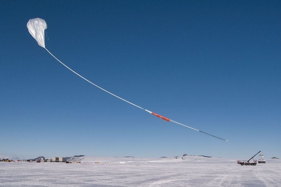 Un globo blanco con una larga cuerda flotando sobre el suelo helado. Esta imagen muestra a PUEO en las instalaciones de globos de larga duración en la Antártida, inmediatamente después del lanzamiento del globo. Crédito: NASA/Batallón Scott