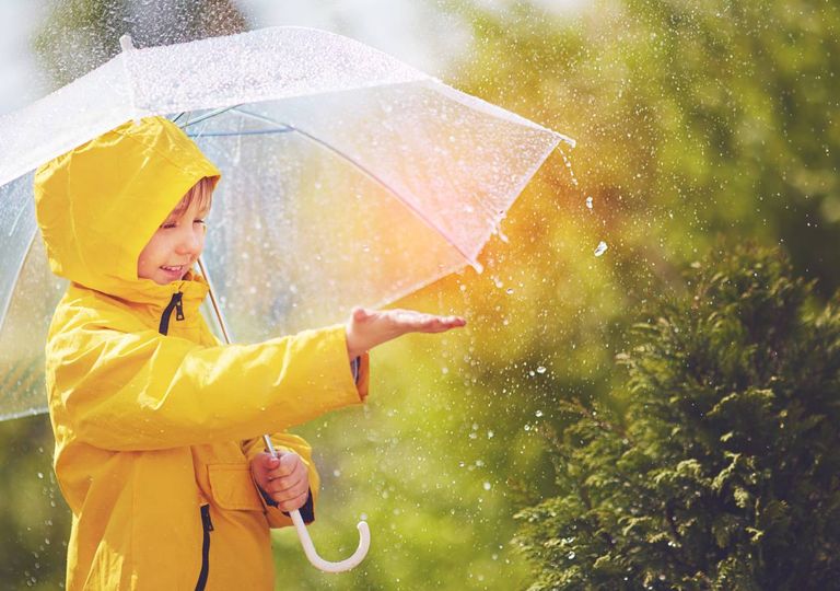 Criança apanha gotas da chuva Criança apanha gotas da chuva