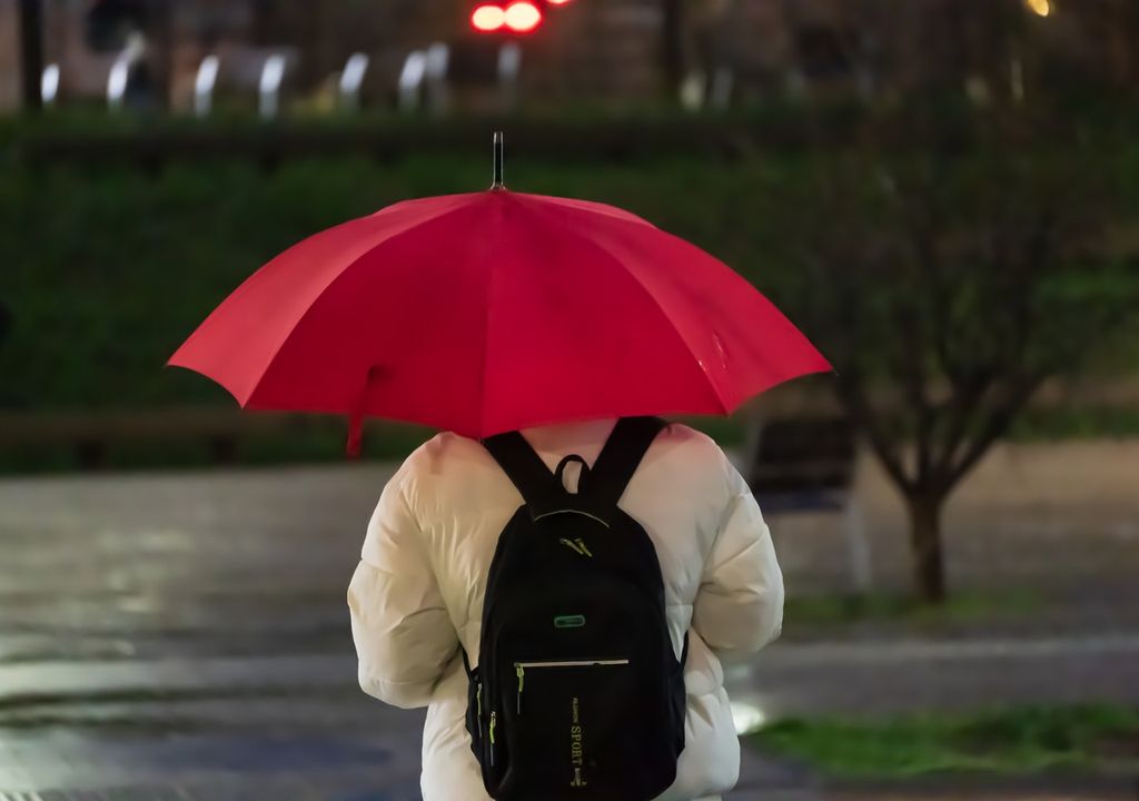 persona con paraguas rojo