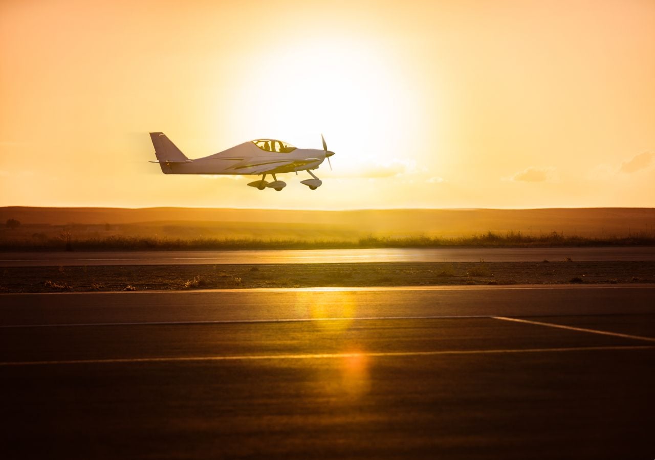 Avión pequeño despegando en un día caluroso.