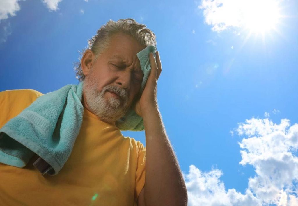 idoso sob sol forte com calor