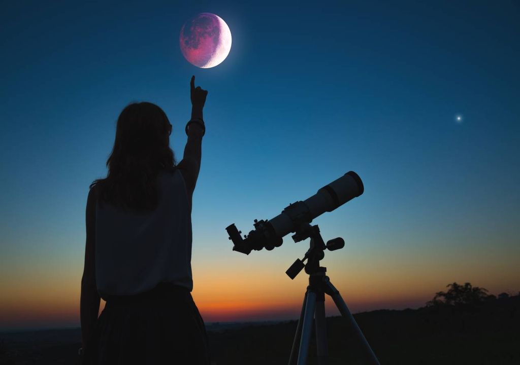 Rapariga com telescópio e eclipse lunar
