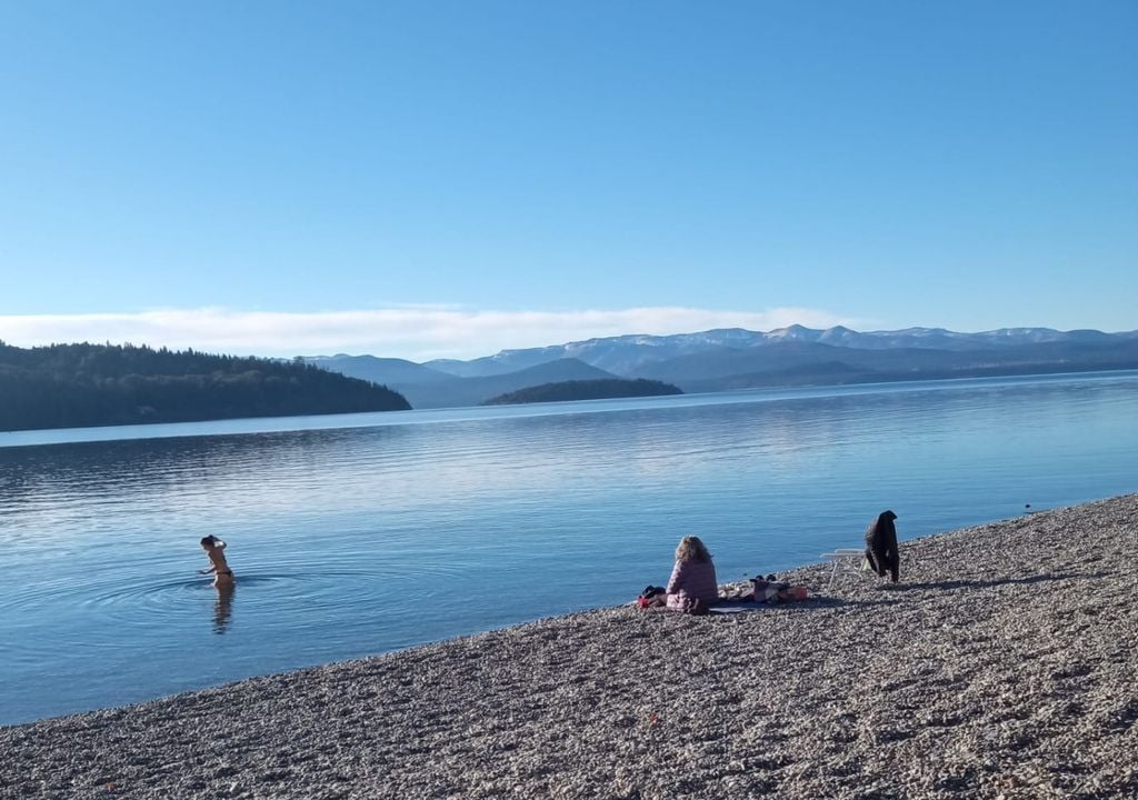 Bariloche lago Esta imagen corresponde a Playa Bonita (Lago Nahuel Huapi - Bariloche) y fue tomada el pasado domingo 14 de junio. Con un cielo casi despejado y el lago prácticamente planchado, la región ha sostenido una seguidilla de días muy estables. Nótese que en la foto se observa a alguien que se animó y se dio un baño en las frías aguas del lago en pleno junio!. Crédito de la imagen: Margarita Ruda.