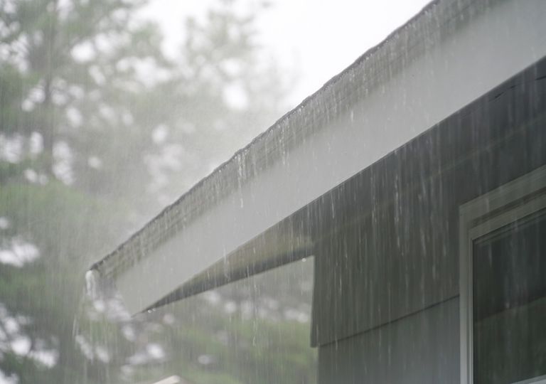 Lluvia vista cayendo en la lateral de una casa Lluvia vista cayendo en la lateral de una casa