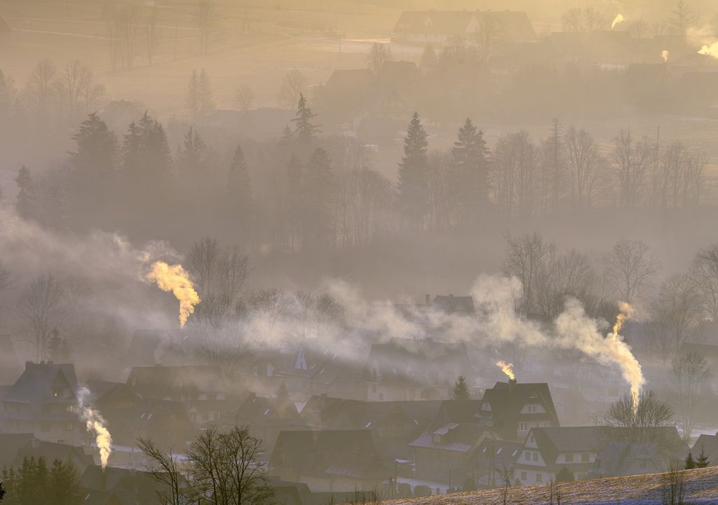 casas con chimeneas liberando humos visibles a la atmósfera