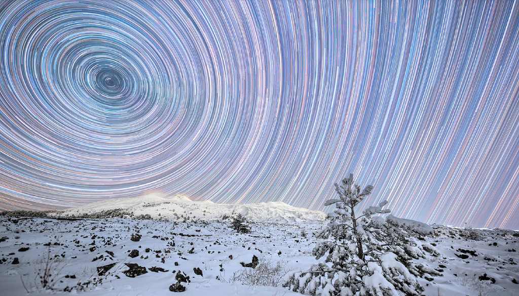 Gli "startrails", i cerchi concentrici delle stelle circumpolari e gli archi di cerchio di quelle non circumpolari attorno alla Stella Polare visti da piano Vetore sull'Etna. Credit: Dario Giannobile