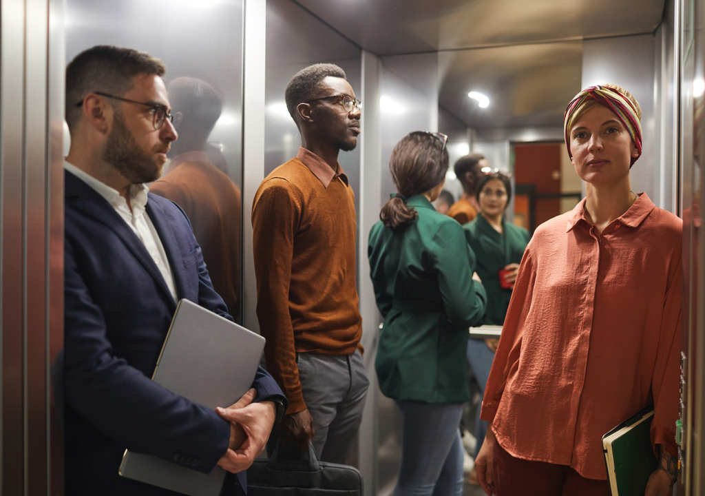Personas dentro de un ascensor durante un trayecto cotidiano, donde los cambios de aceleración pueden alterar momentáneamente la sensación de peso sin modificar la masa corporal.
