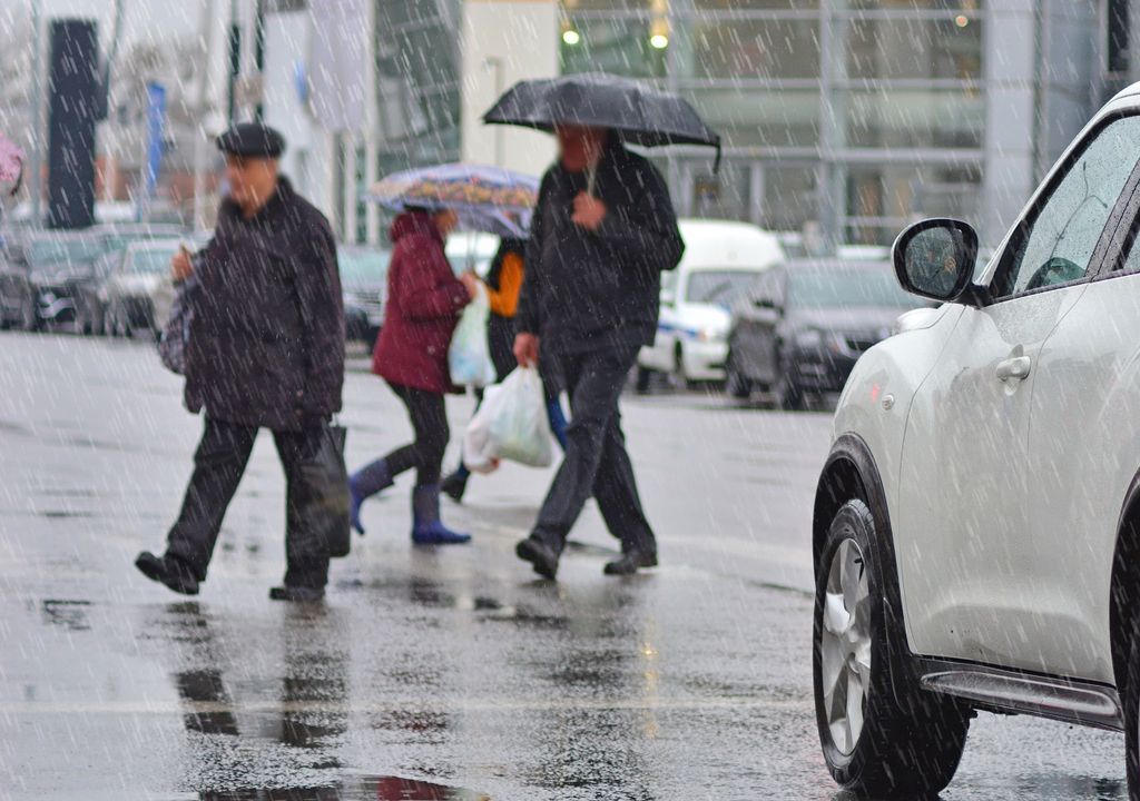 personas cruzando la calle en un día de lluvia