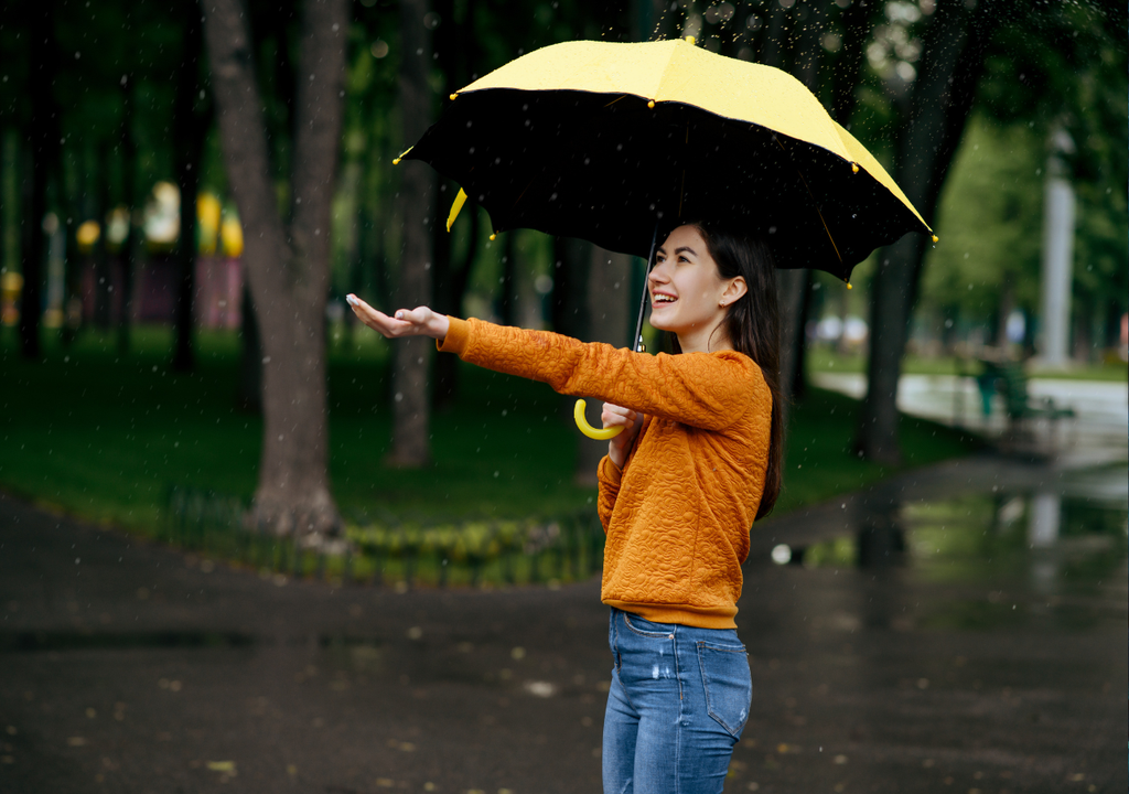 mujer con paragua esperando la lluvia.
