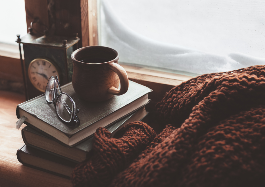 café, anteojos, libros y manta.