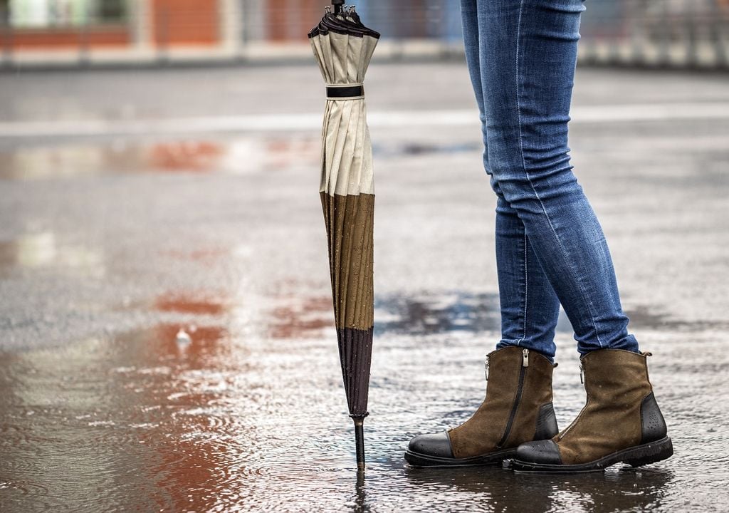 mujer en pie bajo la lluvia