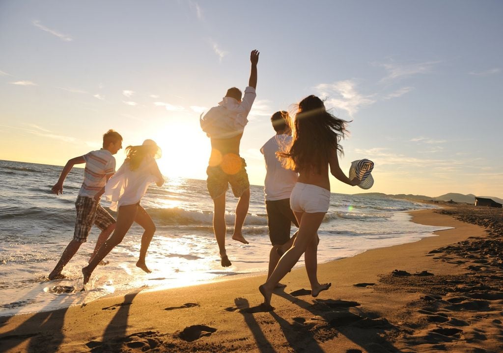 personas corriendo en la playa