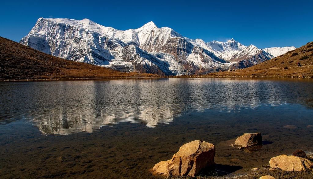 Il massiccio montuoso dell'Annapurna in Nepal si specchia in un lago a quasi 5000 metri di altitudine