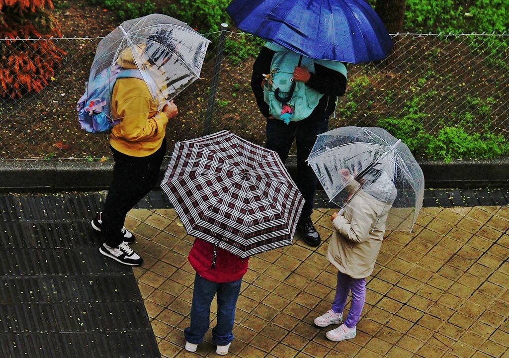 personas con paraguas bajo la lluvia