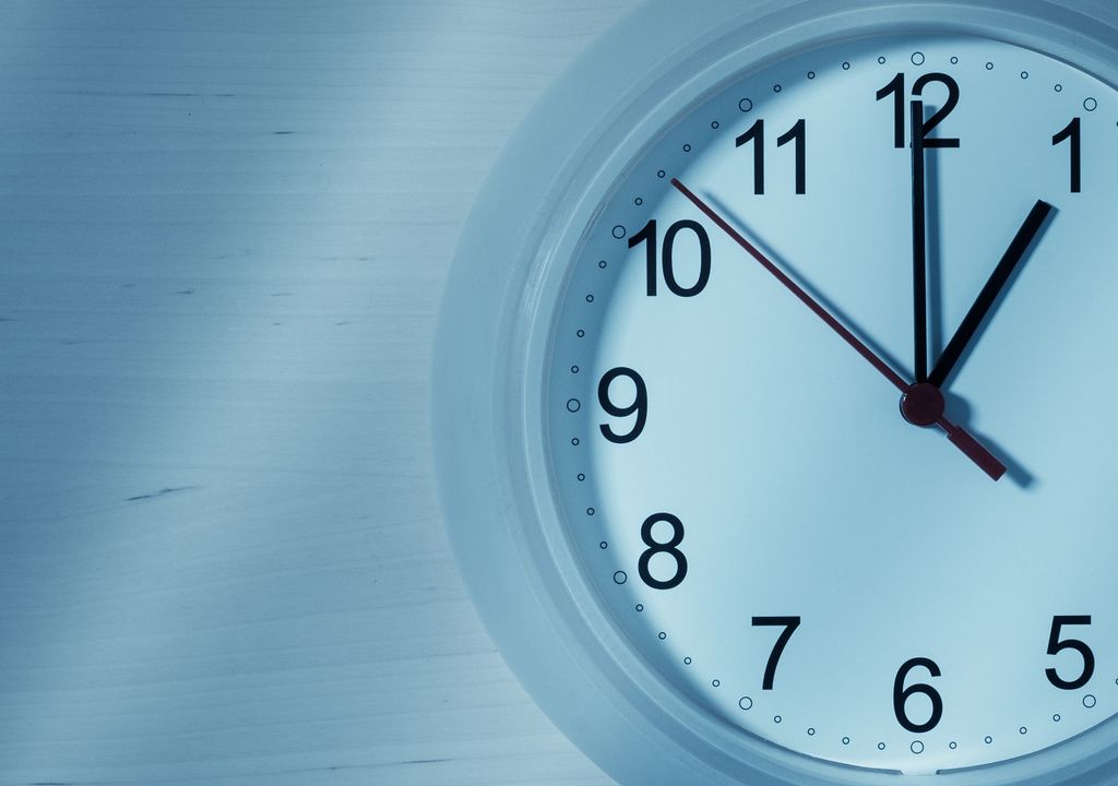 Reloj blanco de pared marcando las 01:00