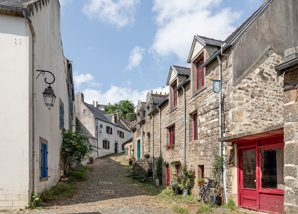 Une ruelle pavée serpente entre les maisons de caractère.