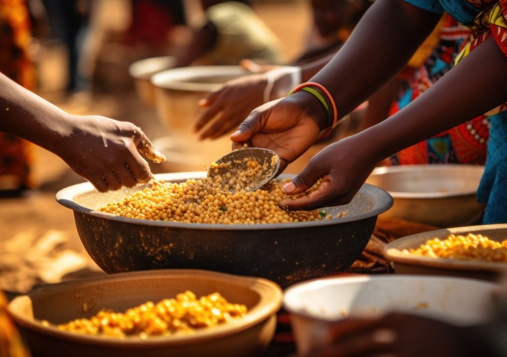 personas repartiendo y compartiendo comida; África