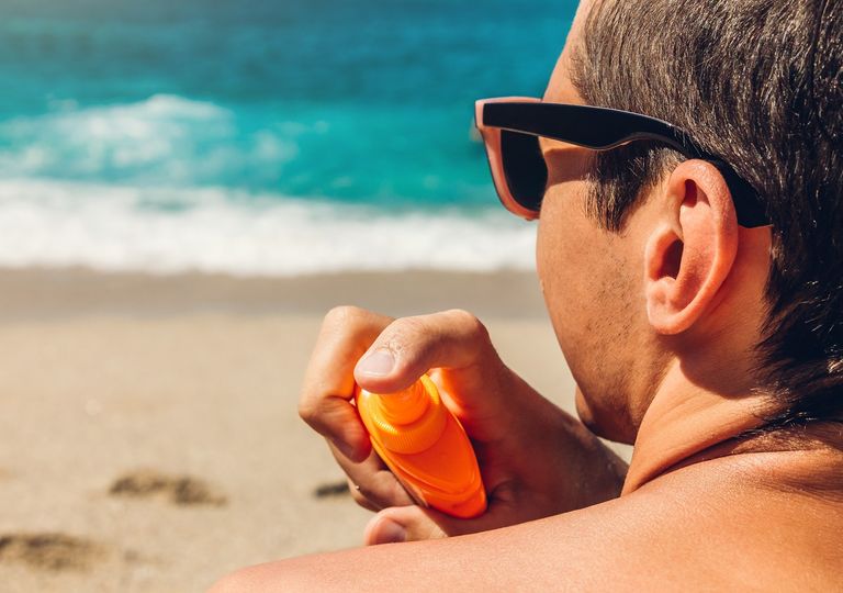 hombre usando lentes de sol y aplicando protector solar en la piel hombre usando lentes de sol y aplicando protector solar en la piel