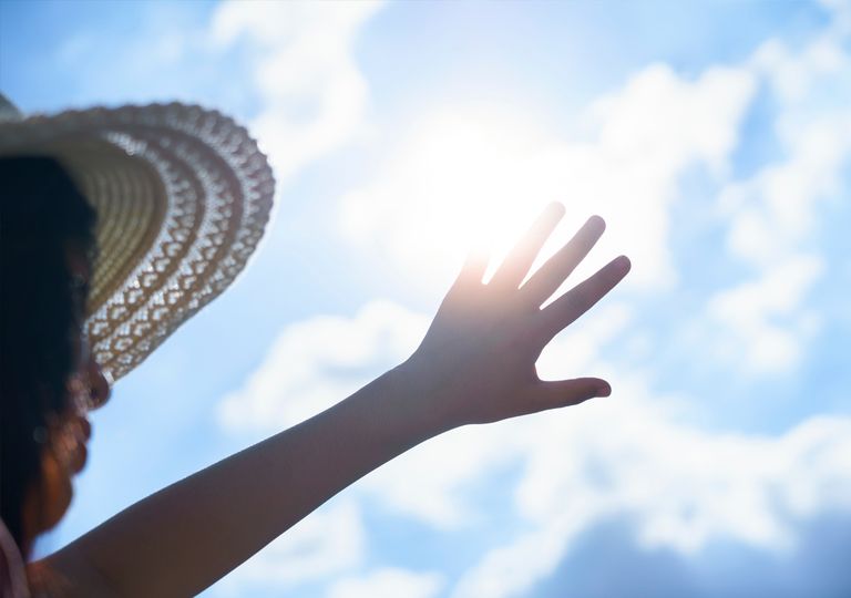 Mujer tapa el sol con la mano Mujer tapa el sol con la mano