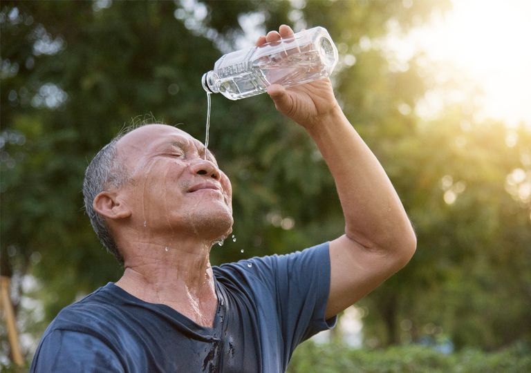 Persona mayor hidratándose con agua Persona mayor hidratándose con agua
