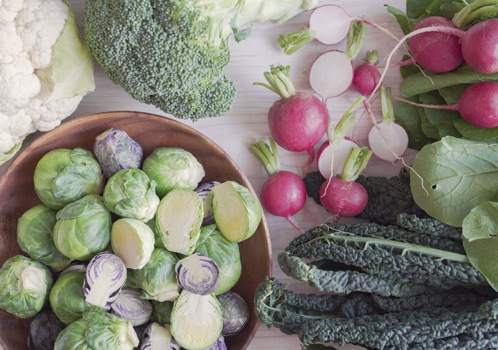Brocoli, rábanos, bruselas, coliflor sobre mesa blanca