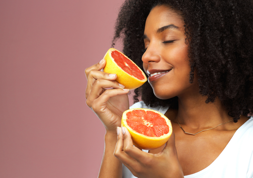 Mujer oliendo un pomelo