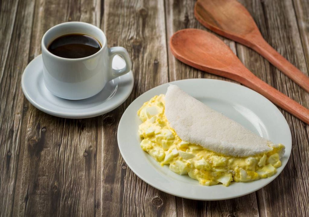 una taza de café y una tortilla con huevos, desayuno