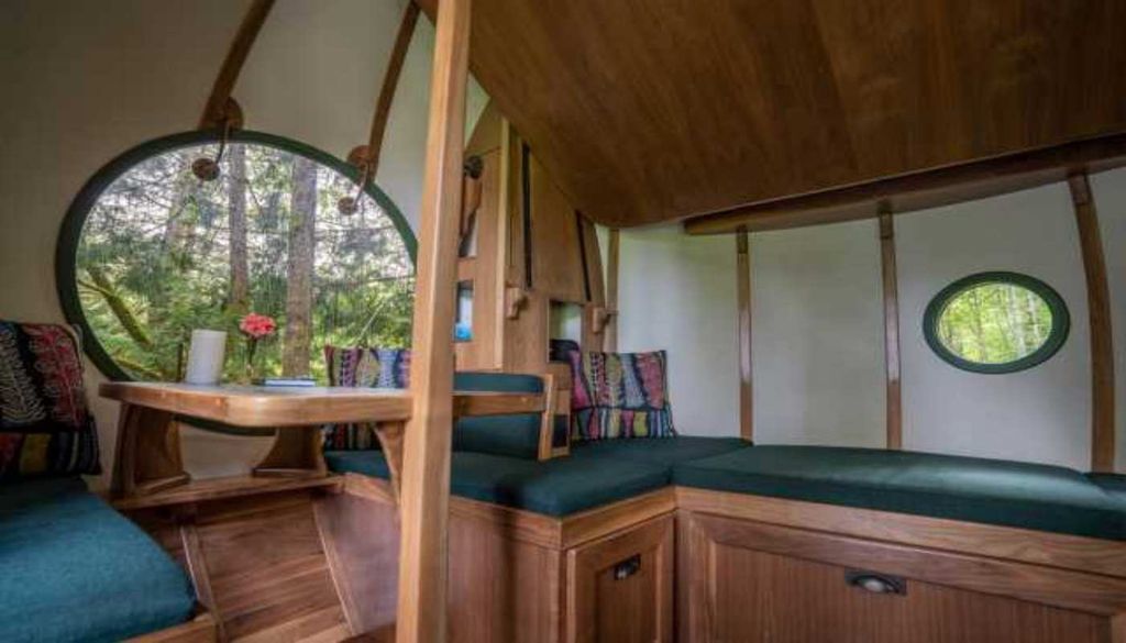 Interior da espera Luna Com madeira trabalhada, mobiliário sob medida e iluminação aconchegante, o interior das esferas são transformados num refúgio suspenso entre as copas das árvores. Fonte: FreeSpiritSphere