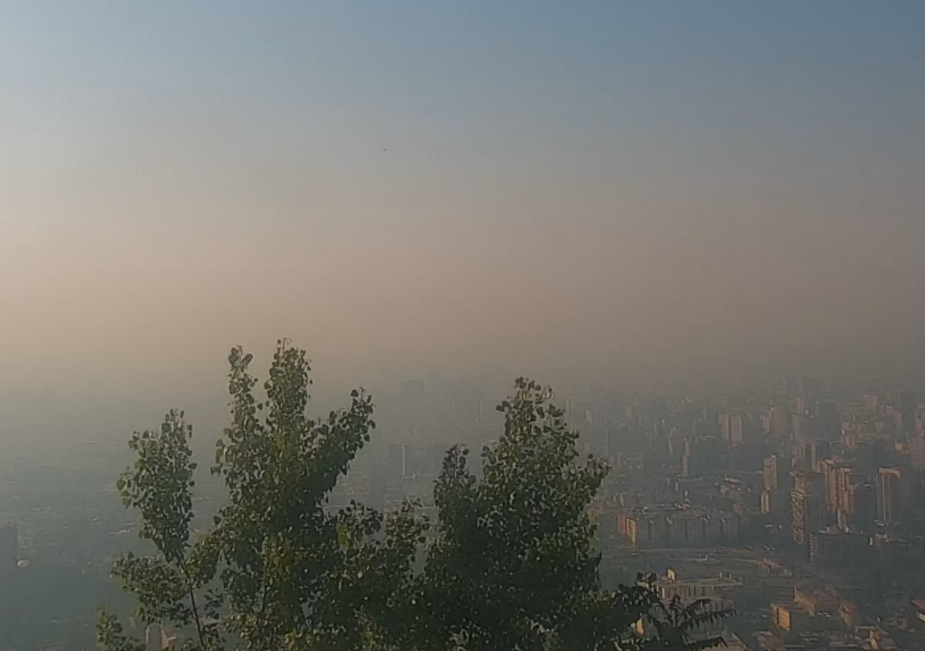 Una densa nube de contaminación cubre Santiago durante la mañana del 17 de diciembre de 2025, evidenciando un episodio de mala calidad del aire asociado a escasa ventilación y aporte de emisiones urbanas e incendios forestales. Créditos: Cámara Parque Metropolitano de Santiago (PARQUEMET).