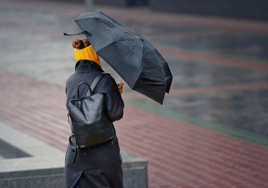 persona con paraguas contra el viento